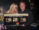 Overton presents Lambert a plaque for her platinum album, Revolution.